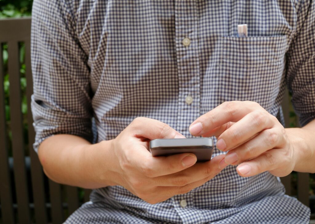 pexels-photo-346734-346734 Close-up of a man using a smartphone, focusing on hands and modern technology.
